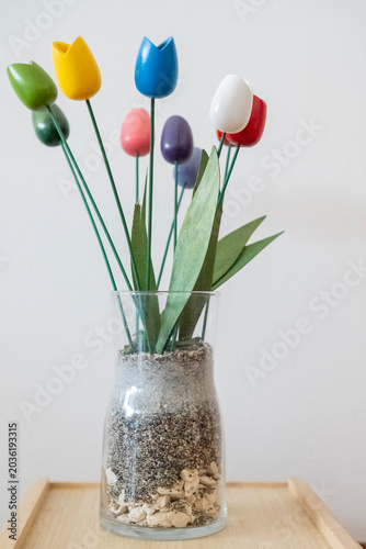 Flowers of various colors inside a glass jar photographed on a white background