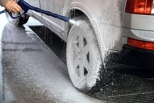 Car washing with a high pressure water jet at an outdoor self-service  car wash station.