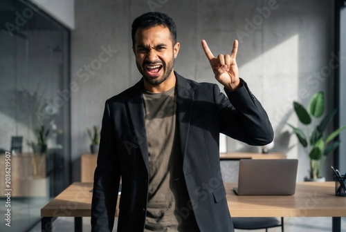 Confident ethnically diverse man shouting while showing excitement at work