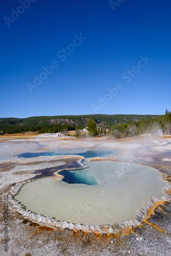 Tableau sur toile Geothermal basins in Yellowstone’s Old Faithful Area with steaming hot springs, mineral-rich waters, and breathtaking natural formations surrounded by pristine wilderness