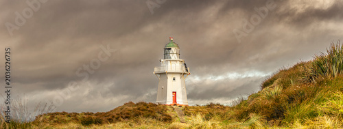 Konstfotografi Lighthouse on coastal path under dramatic storm clouds - White coastal lighthous