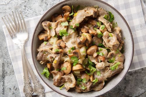 Fotografía Delicious chicken gizzards cooked with mushrooms and onions close-up in a bowl on the table