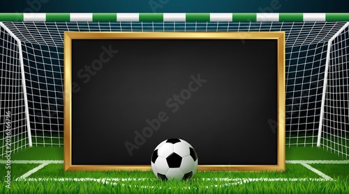 Empty blackboard with golden frame and soccer ball on green grass field