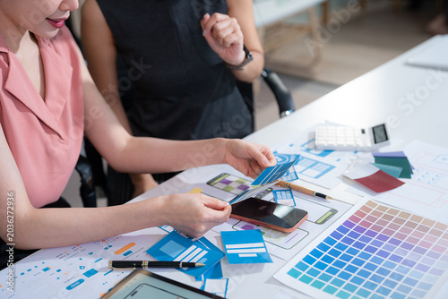 Fotografi UX developer and ui designer brainstorming about mobile app interface wireframe design with customer breif and color code at office