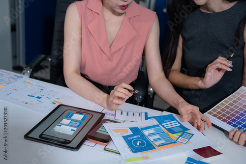 Fotografi UX developer and ui designer brainstorming about mobile app interface wireframe design with customer breif and color code at office