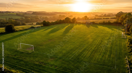 A serene soccer field at sunset with lush green grass and a goal post