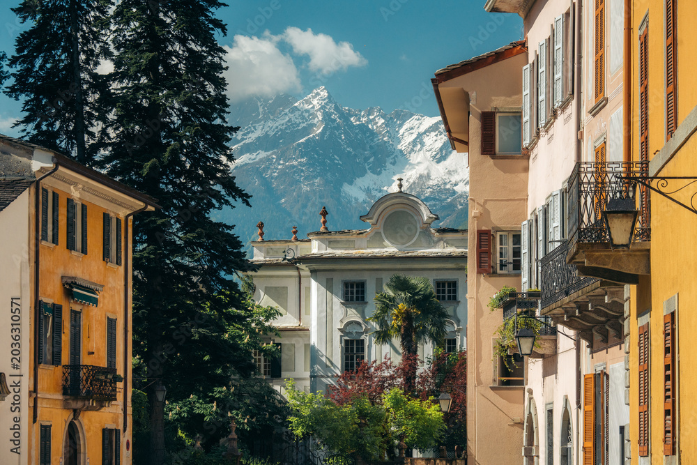Fototapeta premium Chiavenna old town against snowcapped mountains in spring, Lombardy, Italy