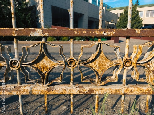Foto Rusted iron fence with decorative design in urban setting