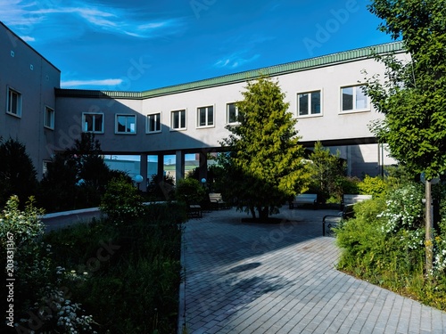 Modern building with green courtyard under bright blue sky