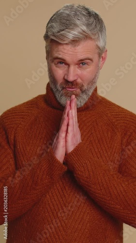 Sneaky cunning middle-aged man with tricky face gesticulating and scheming evil plan, thinking over devious villain idea, cheats, revenge, jokes, pranks. Senior guy isolated on beige studio background