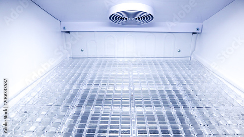 Fotografie Close up inside an empty refrigerator or cooler compartment looking down at a cl