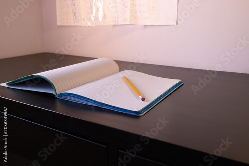 Pencil lying on an open notebook on a table