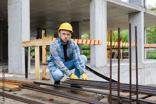 Construction worker inspecting rebar on building site