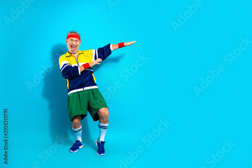 Εκτύπωση καμβά Energetic senior man in retro tracksuit dancing and exercising with a headband a