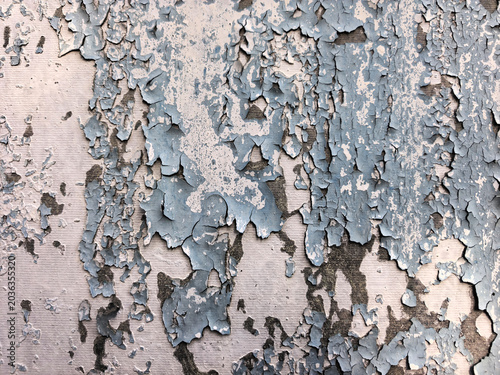 Peeling and cracked paint texture on old wall. Vintage weathered surface with flaking layers. Abstract grunge background for design