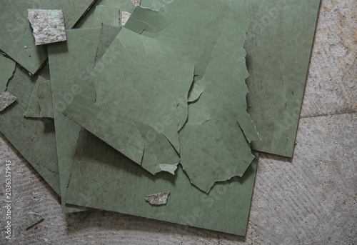 Billede på lærred Green vinyl tile flooring was deteriorated and peeling, and the rough concrete floor was damaged and in contact with the ground