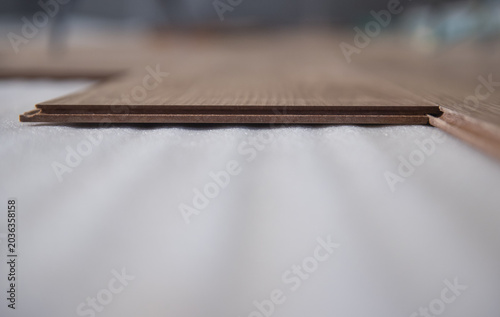 Canvastavla Light oak laminate flooring installed on a white foam backing features a click-lock system for easy assembly