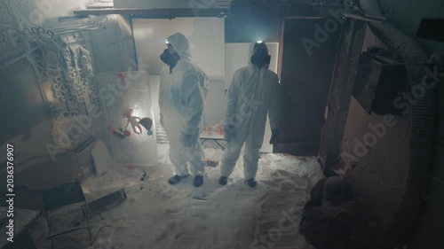 Research crew in protective suits documenting frozen sample recovery inside derelict house with bright headlamp, camera capture and careful vial handling, methodical preservation atmosphere