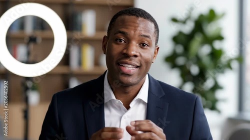 Businessman video call ring light home office online meeting professional remote work webcam speaking communication modern workspace bookshelf background confident presenter entrepreneur portrait
