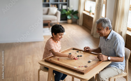 Indian joint family playing carrom board game together at home with chai, analog screen-free family bonding and multigenerational lifestyle India