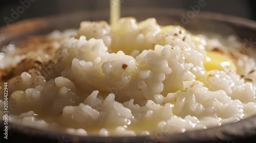 Close up of creamy rice pudding being drizzled with butter.