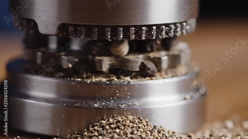 Closeup of a Pepper Grinder Grinding Whole Peppercorns into Freshly Ground Pepper.