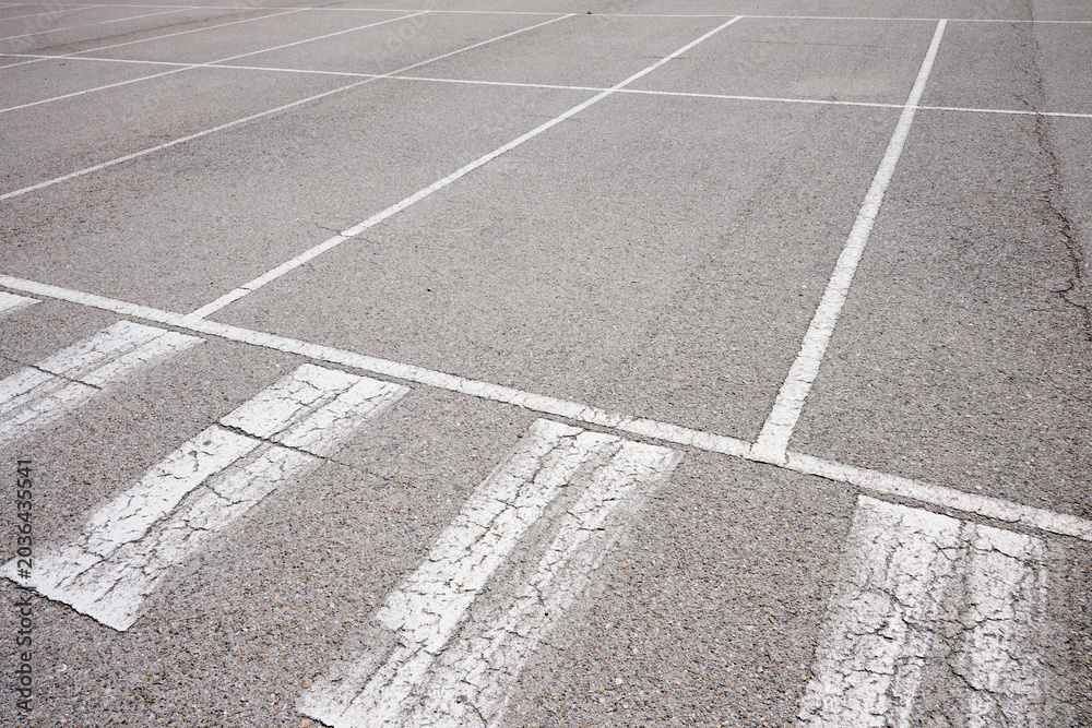 Fototapeta premium White lines painted on the ground in an asphalt parking lot