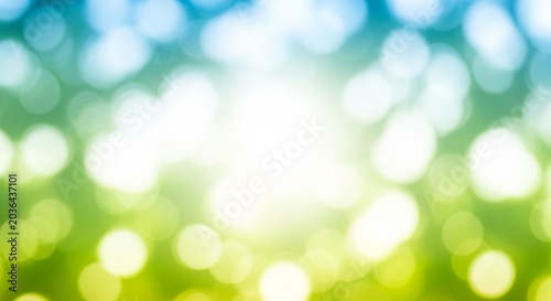 Abstract blue and green bokeh background with bright central light for nature-themed designs