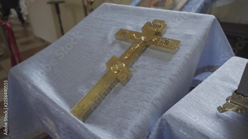 Close-up view of beautifully crafted golden crucifix, figure of Christ, delicate details of cross and sacred iconography, solemn atmosphere of church setting, spiritual significance, reverence.