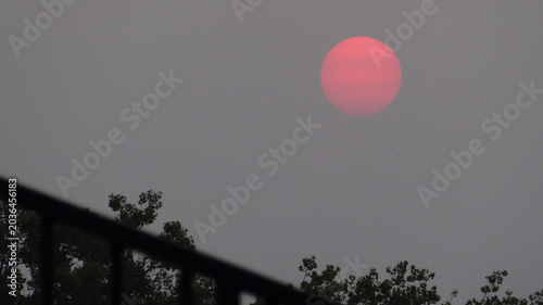 Dim red sun in a smoky purple sky