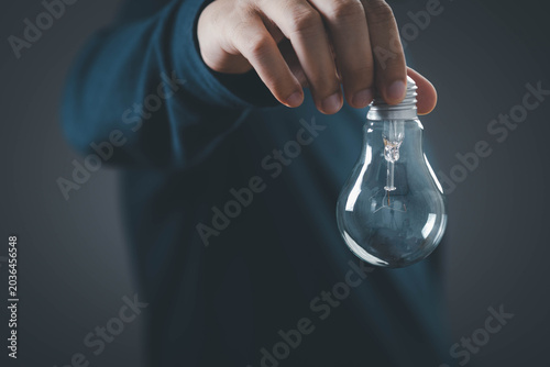 Fotografie Idea concept with hand holding light bulb, symbol of creativity, innovation and
