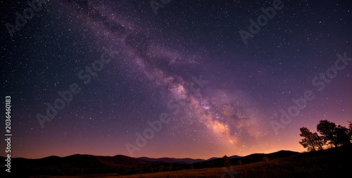 Vast Milky Way Galaxy Arching Over a Silhouetted Landscape at Night.