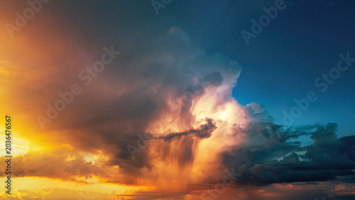 фотографія Dramatic storm clouds illuminated in vivid orange tones at sunset