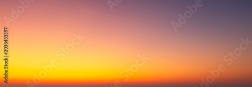 Fotografía Vibrant Golden Hour Sky Gradient Background,A smooth, abstract gradient of a stunning sunset sky transitioning from deep purple and orange to a bright, warm golden yellow horizon, perfect for use
