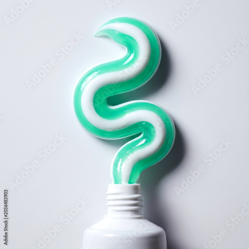 Striped green and white toothpaste squeezed in a wave from tube