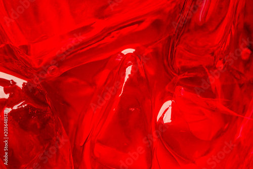 Fotografie Abstract Macro View of Vibrant Red Gelatin Texture,A close-up, high-contrast abstract macro shot capturing the smooth, fluid, and translucent texture of vibrant red gelatin with soft highlights