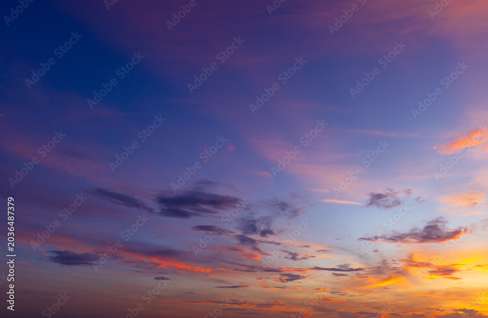 Fototapeta premium Dramatic golden hour sky with colorful sunset clouds,A breathtaking panoramic view of a dramatic golden hour sky, featuring vibrant orange, pink, and purple sunset clouds scattered across a deep blue 