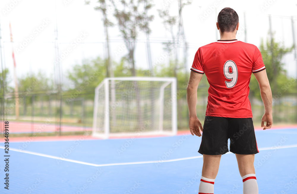 Obraz premium Football player in a red jersey with number 9 from behind