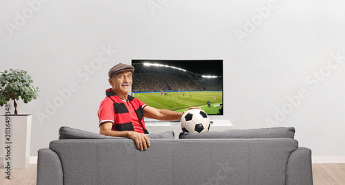 Senior football fan watching a match on tv