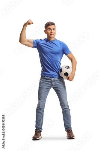 Fotografie Young man in blue shirt flexing arm and holding a football