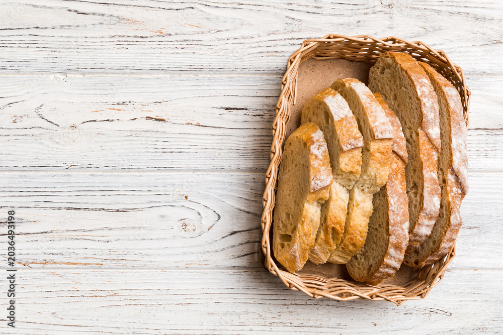Obraz premium Freshly baked bread slices on basket against natural background. top view Sliced bread