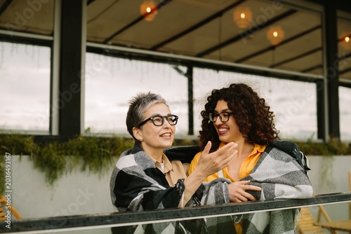 Two women sharing generational friendship moments on balcony