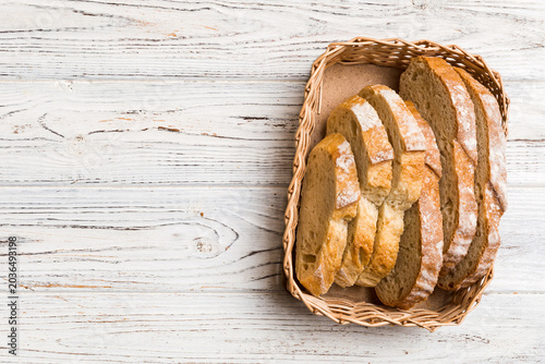 Freshly baked bread slices on basket against natural background. top view Sliced bread