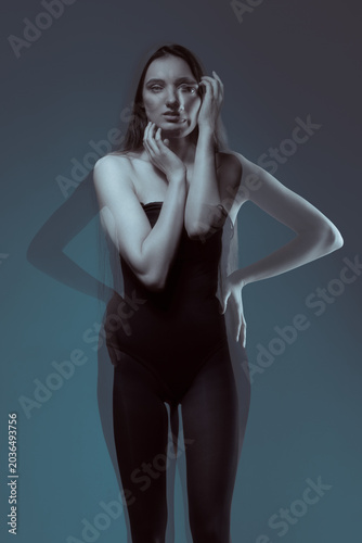 Young woman posing with a surreal double exposure effect creating a ghostly optical illusion