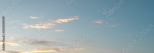 Soft clouds in a clear evening sky. Pale light over open air creates a calm natural backdrop. Ideal for weather, travel, and copy space use..