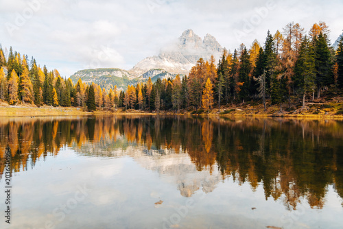Scenic Alpine Lake in Autumn, Vibrant Fall Forest and Distant Mountain Peak on the Horizon in Natural Light