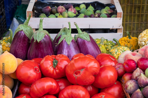 Tomatoes and eggplants. Vibrant Farmers' Market Stall with Fresh Organic Produce. Colorful Vegetables and Fruits in Natural Light