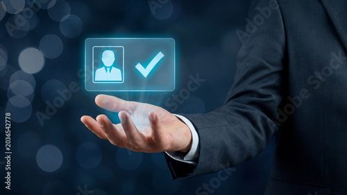 Businessperson's hand holding a glowing digital identity icon with a checkmark, representing online user verification and approval