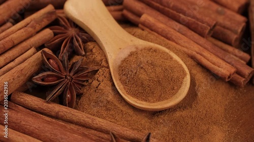 Cinnamon powder and cinnamon sticks close up, rotation. Warm, aromatic spice is a staple in baking and cooking