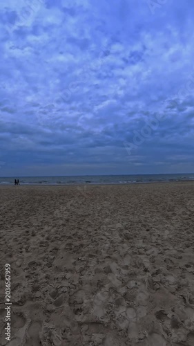 A beach under a dramatic, overcast sky